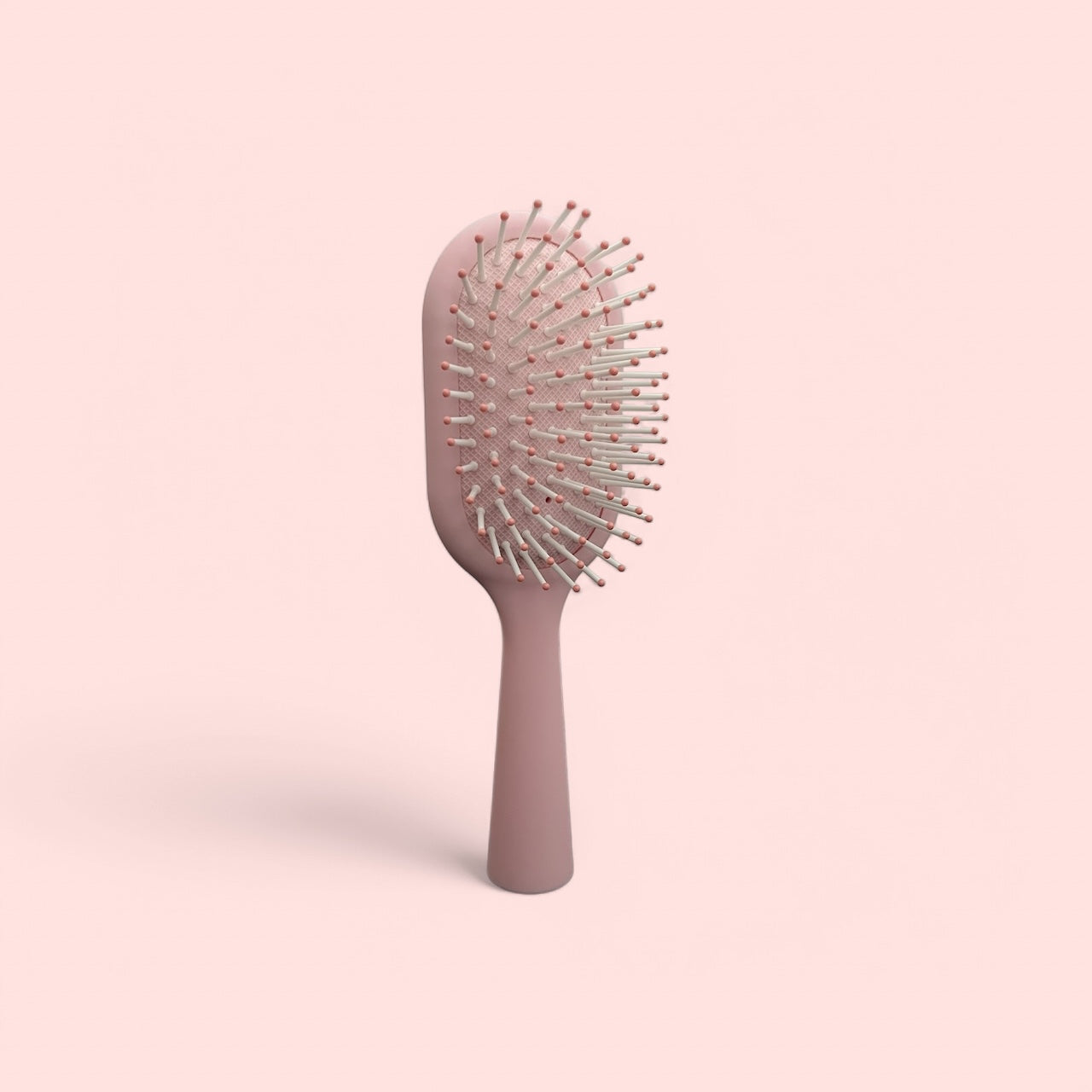 Mini brosse rose Jalia Cosmetics pour démêler et coiffer les cheveux bouclés
